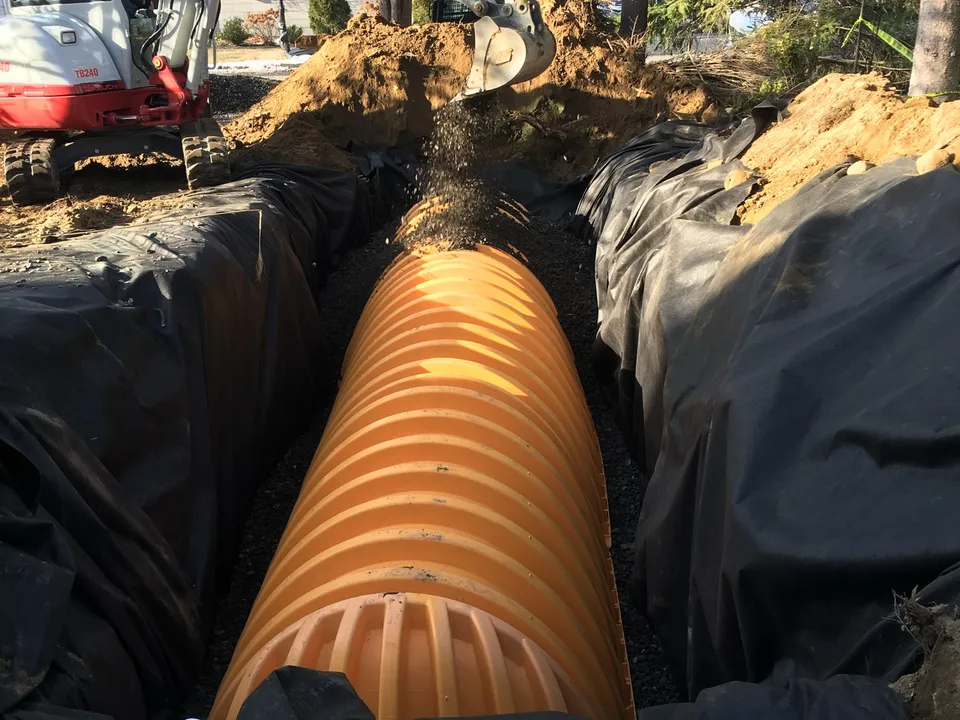 Large corrugated drain pipe set in a lined trench at a home